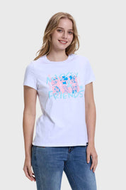 Polera blanca de mujer con diseño de Mickey y sus amigos, modelo de pie mostrando la prenda.