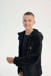 Polar niño negro con textura suave y cierre frontal liso sin estampado ideal para días fríos y casuales