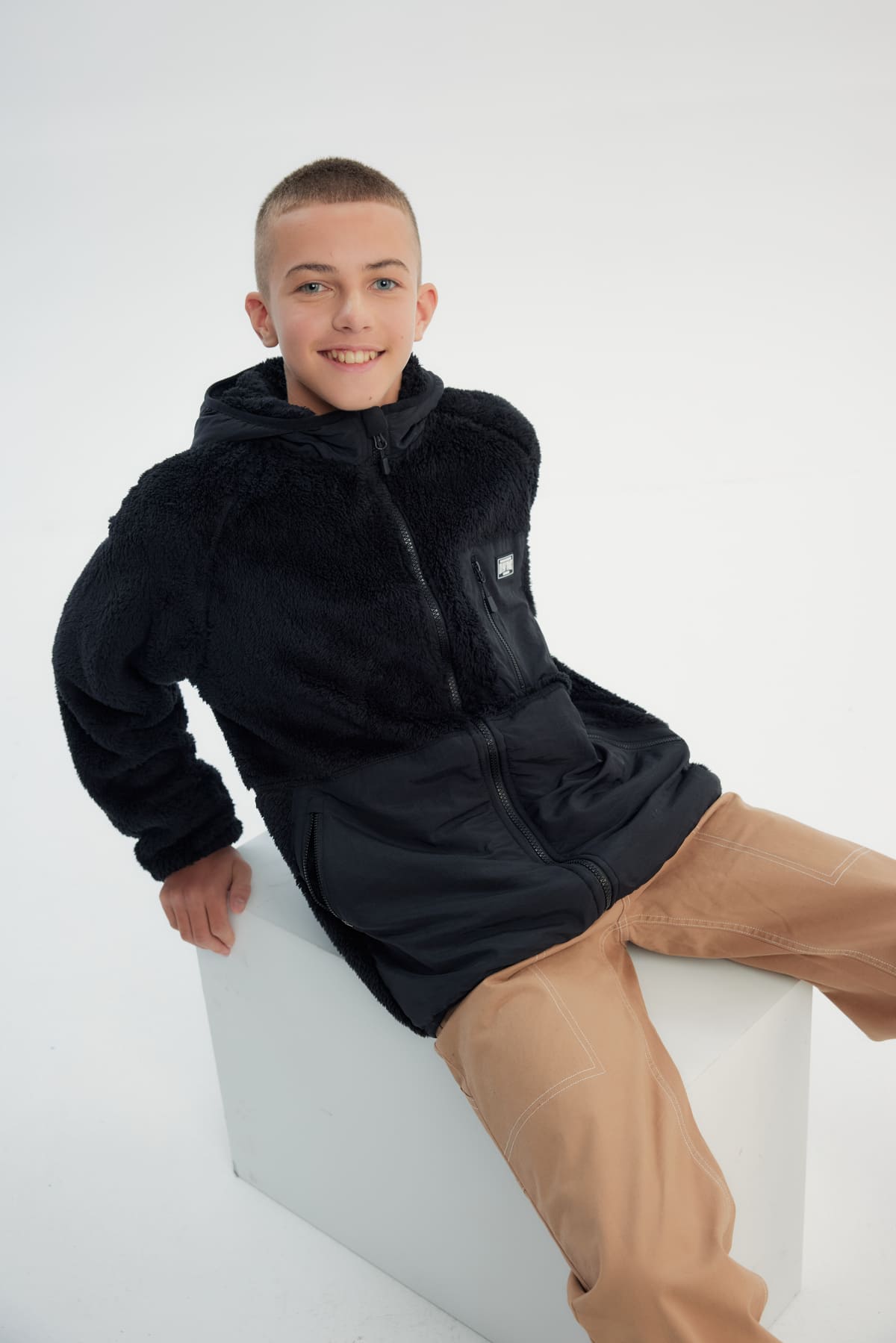 Polar niño negro con textura suave y cierre frontal liso sin estampado ideal para días fríos y casuales