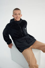 Polar niño negro con textura suave y cierre frontal liso sin estampado ideal para días fríos y casuales