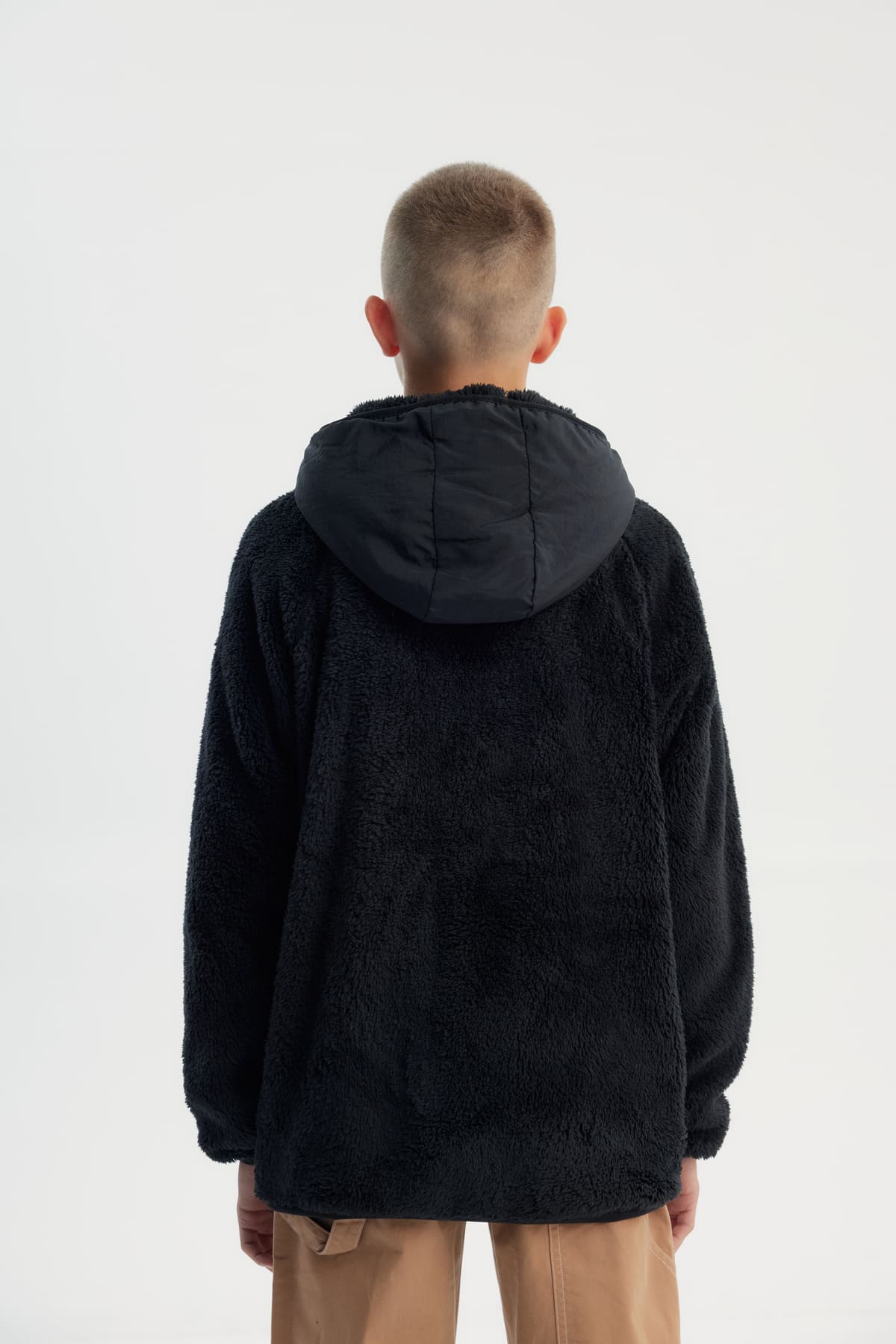 Polar niño negro con textura suave y cierre frontal liso sin estampado ideal para días fríos y casuales