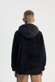 Polar niño negro con textura suave y cierre frontal liso sin estampado ideal para días fríos y casuales