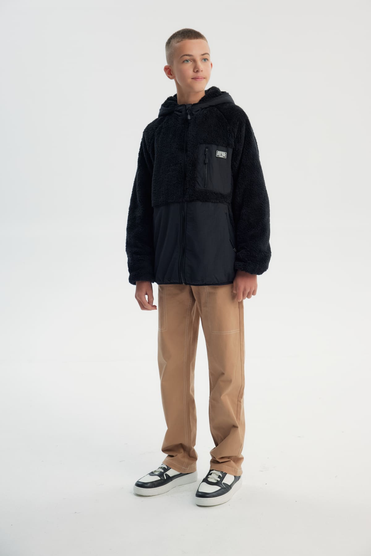Polar niño negro con textura suave y cierre frontal liso sin estampado ideal para días fríos y casuales