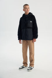 Polar niño negro con textura suave y cierre frontal liso sin estampado ideal para días fríos y casuales