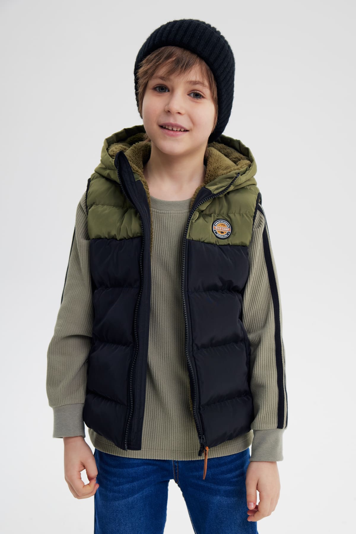 Parka niño sin mangas verde militar con capucha y parche pequeño en el pecho diseño acolchado bicolor verde y negro