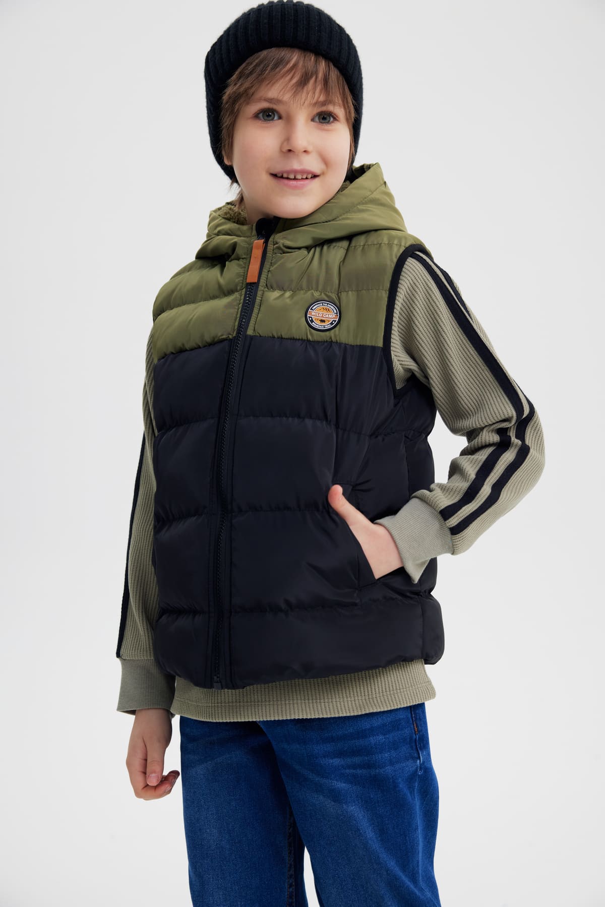 Parka niño sin mangas verde militar con capucha y parche pequeño en el pecho diseño acolchado bicolor verde y negro
