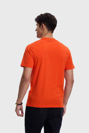 Polera hombre Dragon en color naranjo con estampado icónico.