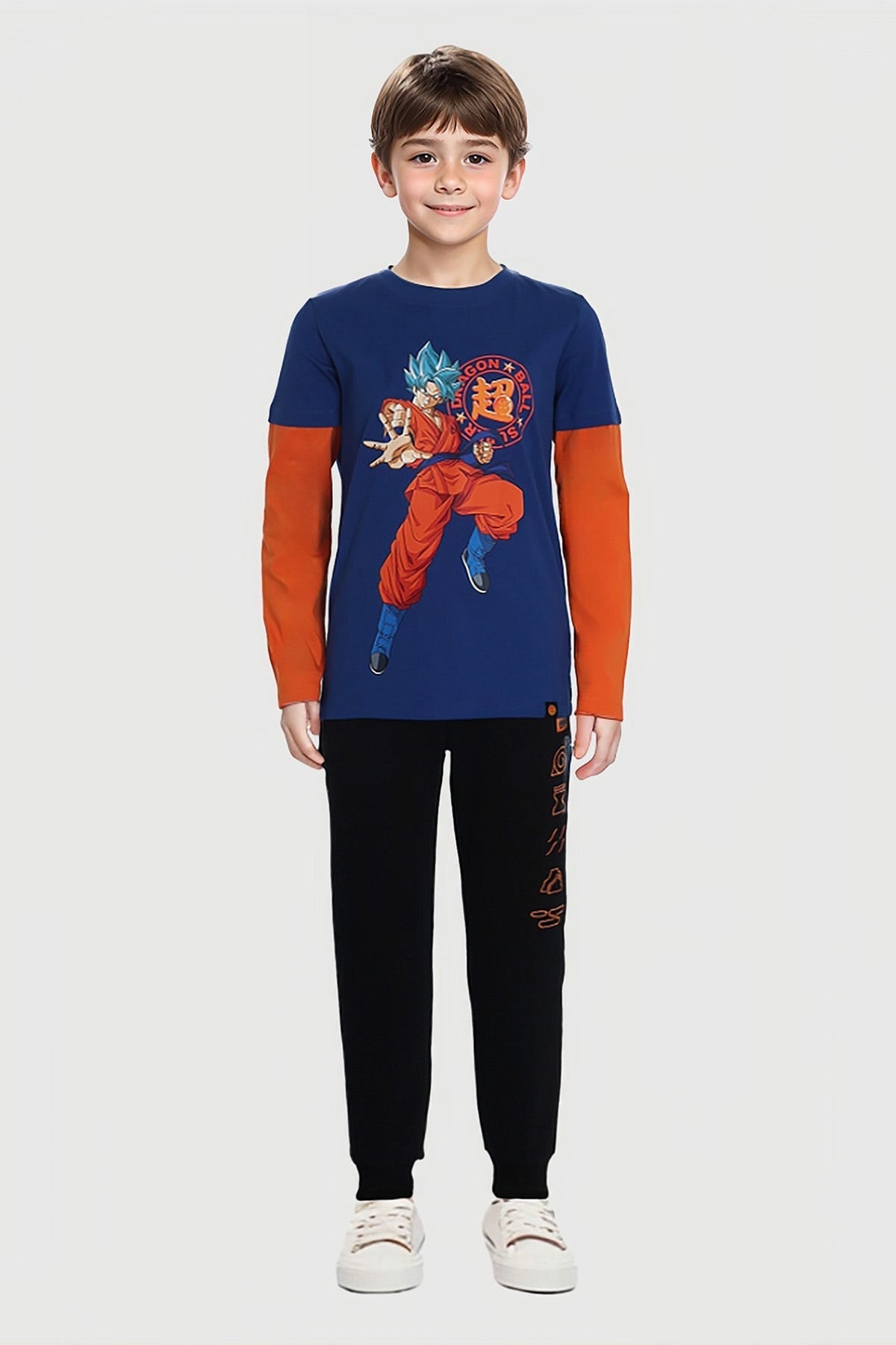 Pantalón buzo negro para niño con diseño Naruto y detalles en naranja.