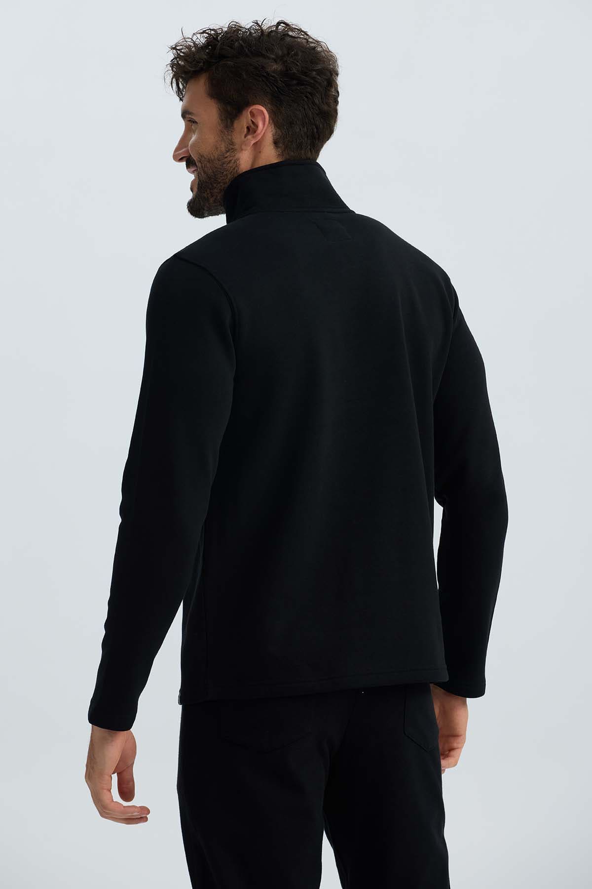 Polerón hombre negro con medio cierre y diseño liso.