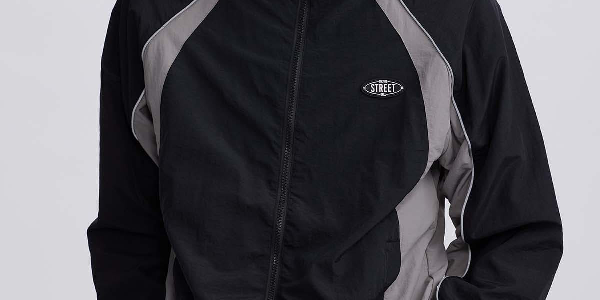 Chaqueta cortaviento negra con detalles grises y logo Street en el pecho estilo casual y deportivo sin estampa adicional