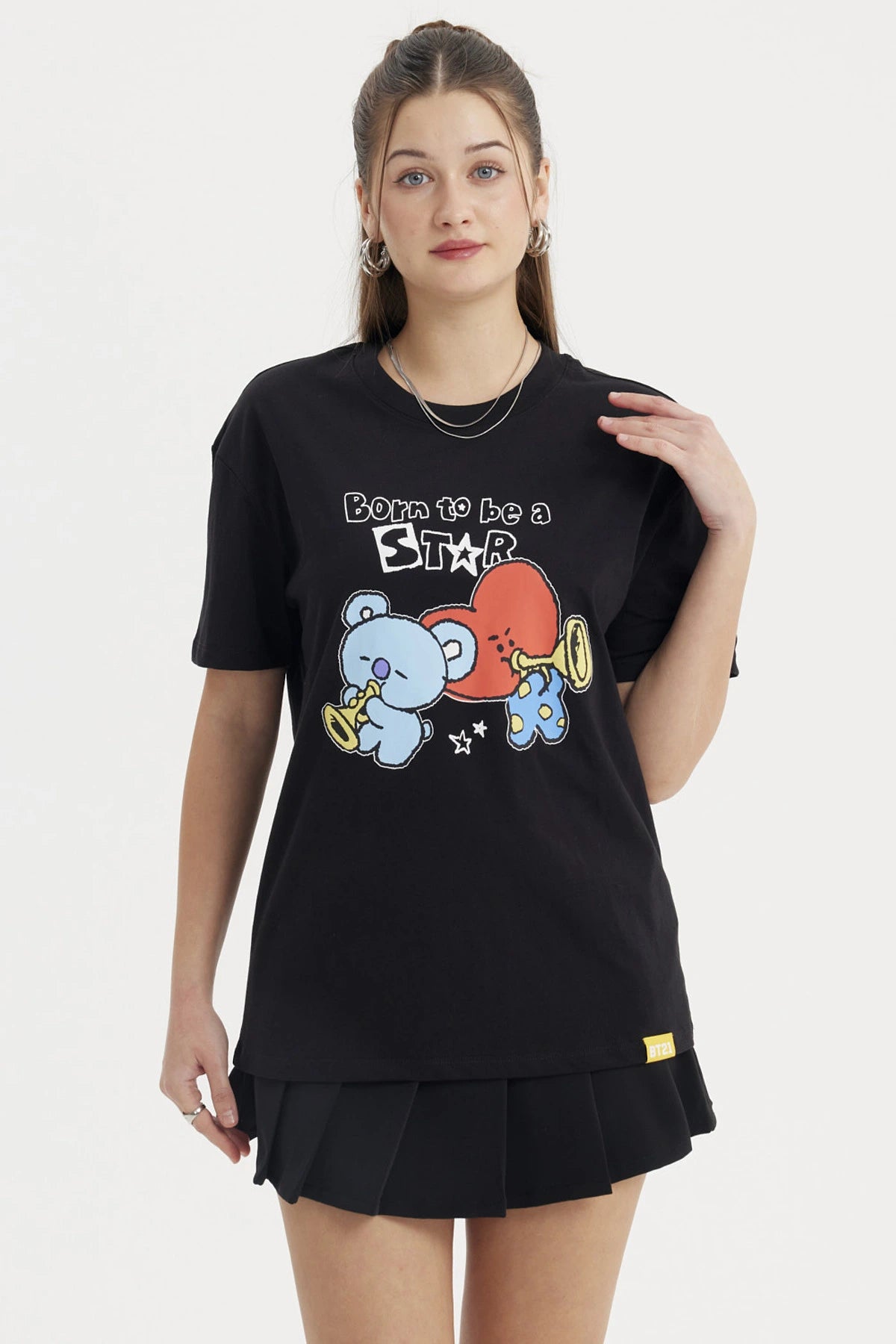 Polera negra de mujer con estampado de personajes BT21 tocando trompetas al frente con texto Born to be a Star