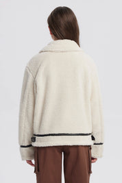 Chaqueta de niña color crudo con cuello camisero cierre frontal negro y detalles en los puños sin estampa lisa
