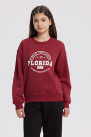 Polerón niña burdeo con estampa frontal Florida 1985 estilo universitario clásico y cómodo ideal para el invierno