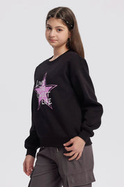 Polerón negro para niña con estampa de estrella rosa y texto Live the Sweet Life al frente en estilo gráfico moderno