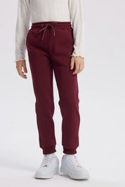 Pantalón jogger burdeo para niña con pretina ajustable y puños elásticos diseño liso ideal para el día a día