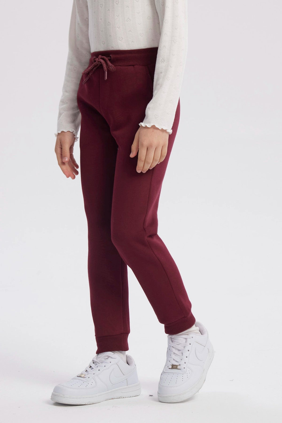 Pantalón jogger burdeo para niña con pretina ajustable y puños elásticos diseño liso ideal para el día a día