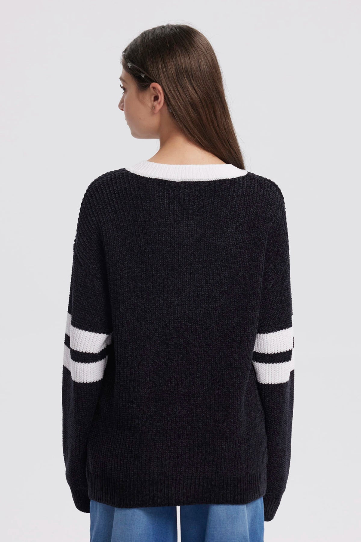 Sweater oversize negro para niña con el número 90 en blanco al frente y rayas blancas en las mangas estilo deportivo