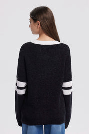 Sweater oversize negro para niña con el número 90 en blanco al frente y rayas blancas en las mangas estilo deportivo