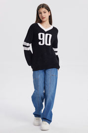Sweater oversize negro para niña con el número 90 en blanco al frente y rayas blancas en las mangas estilo deportivo