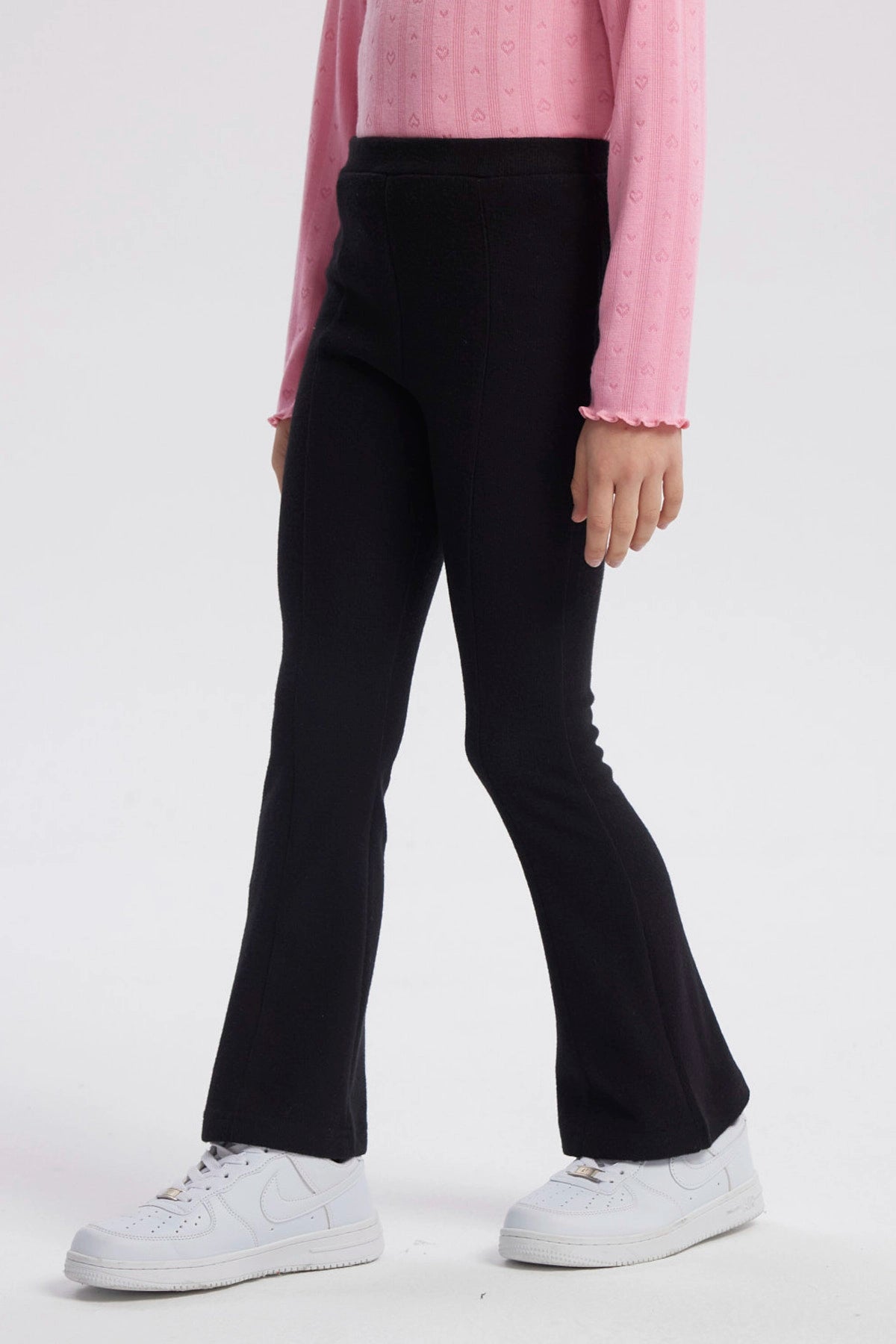 Calza negra para niña tipo flare con diseño liso corte acampanado clásico ideal para cualquier ocasión