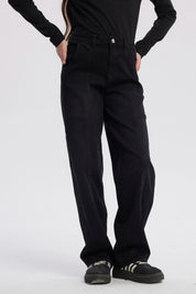 Jeans baggy negro para niña con diseño liso costuras visibles en piernas sin estampado