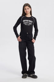 Jeans baggy negro para niña con diseño liso costuras visibles en piernas sin estampado