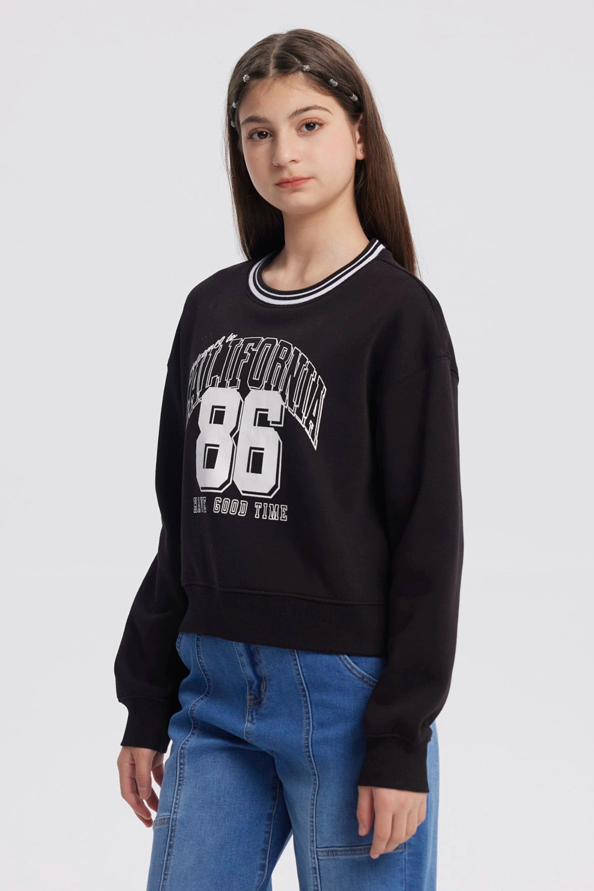 Polerón negro para niña con cuello redondo y estampado frontal California 86 estilo universitario en blanco