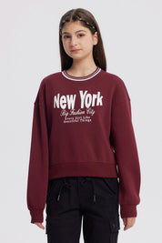 Polerón niña rojo con texto New York y diseño urbano en el frente estilo casual y relajado sin capucha