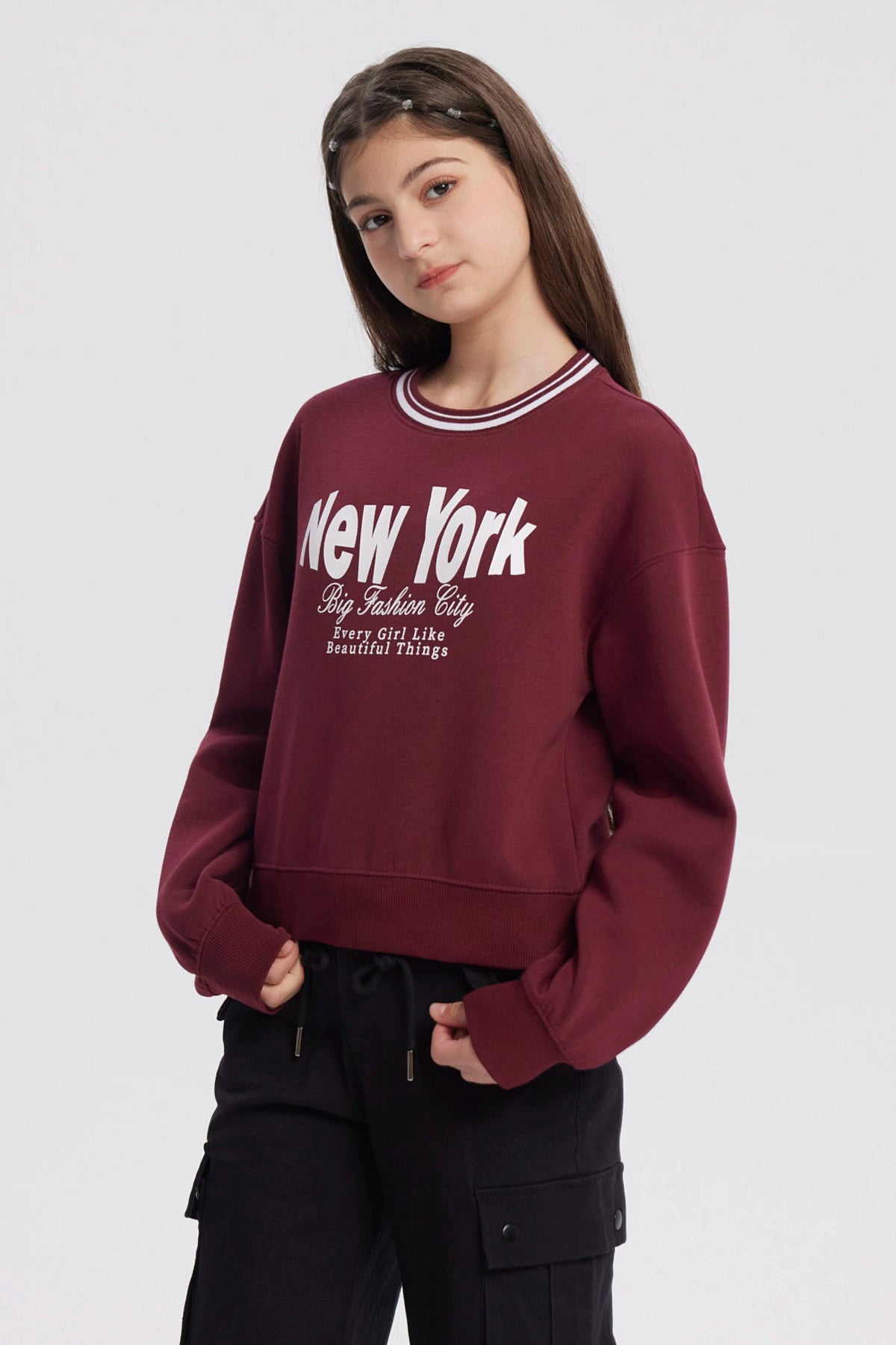 Polerón niña rojo con texto New York y diseño urbano en el frente estilo casual y relajado sin capucha