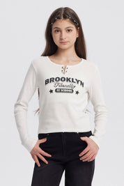 Polera niña cuello redondo blanco con texto Brooklyn Friendly At School en el frente estilo casual sin estampas adicionales