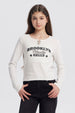 Polera niña cuello redondo blanco con texto Brooklyn Friendly At School en el frente estilo casual sin estampas adicionales