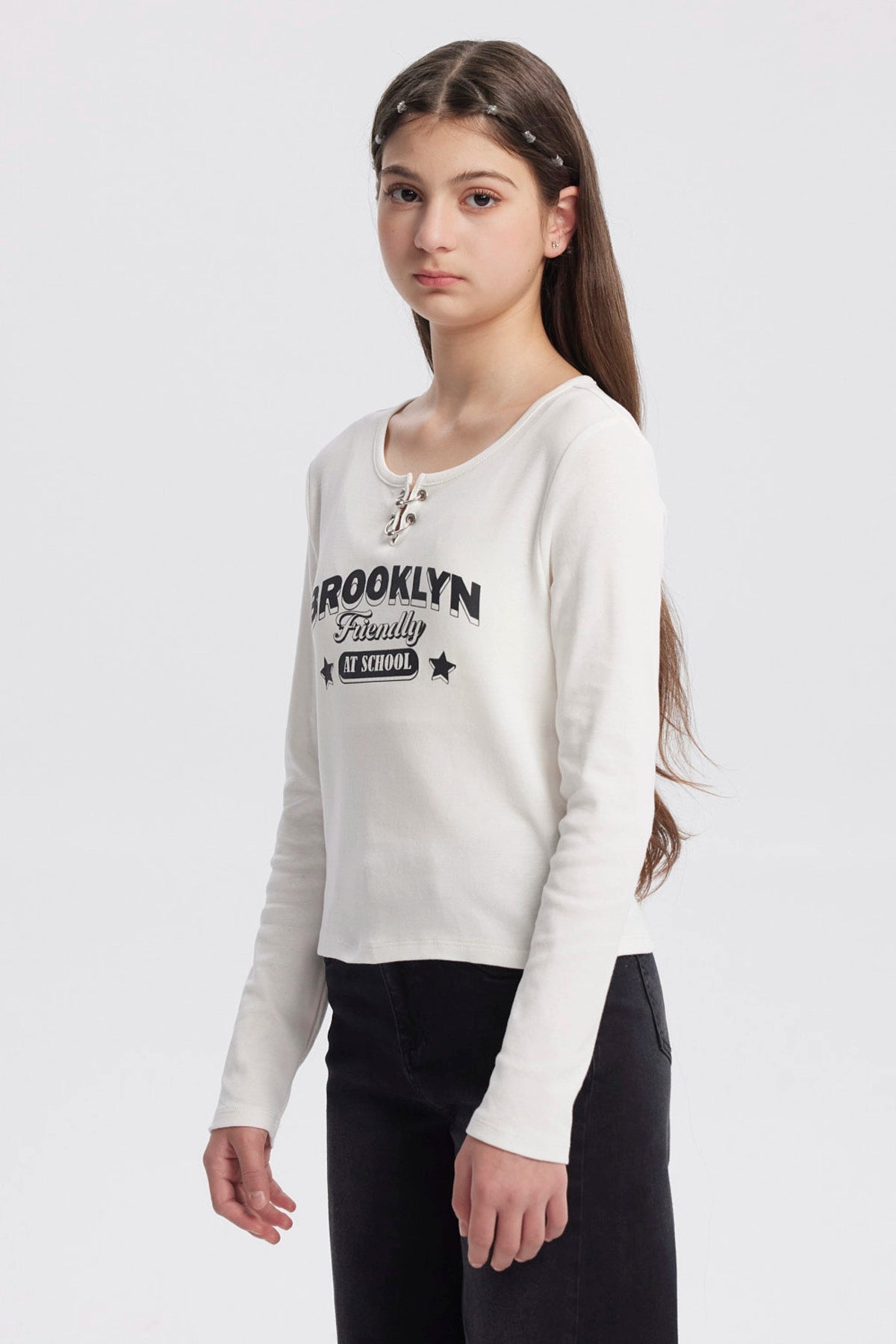 Polera niña cuello redondo blanco con texto Brooklyn Friendly At School en el frente estilo casual sin estampas adicionales