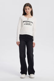 Polera niña cuello redondo blanco con texto Brooklyn Friendly At School en el frente estilo casual sin estampas adicionales