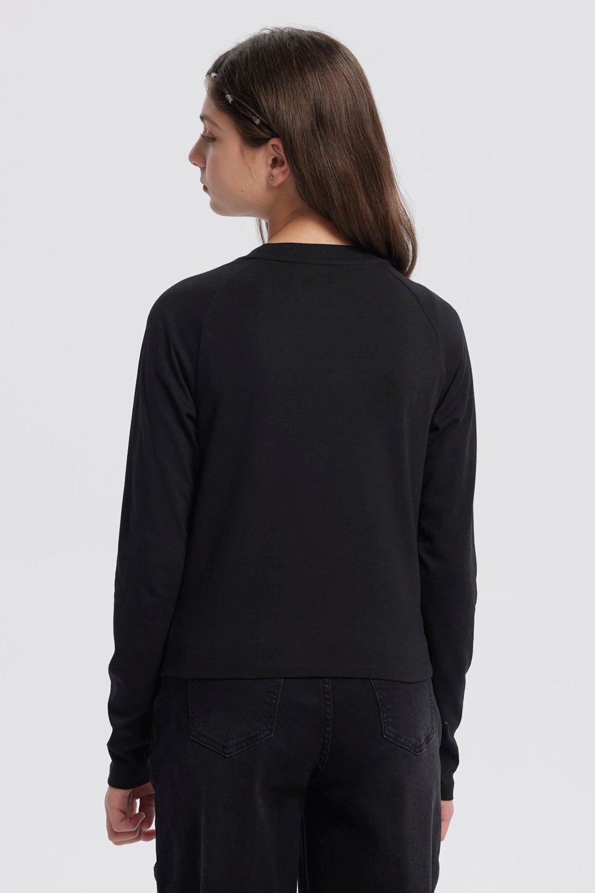 Polera negra de niña con cuello redondo y texto blanco en el pecho que dice Everyday Beauty Happy Time Girls Club