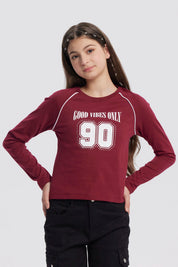 Polera niña roja con cuello redondo y texto Good Vibes Only 90 en el frente en estilo deportivo