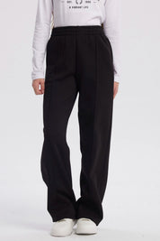 Pantalón buzo negro para niña con pierna ancha sin estampa visible diseño liso y cintura elástica para comodidad
