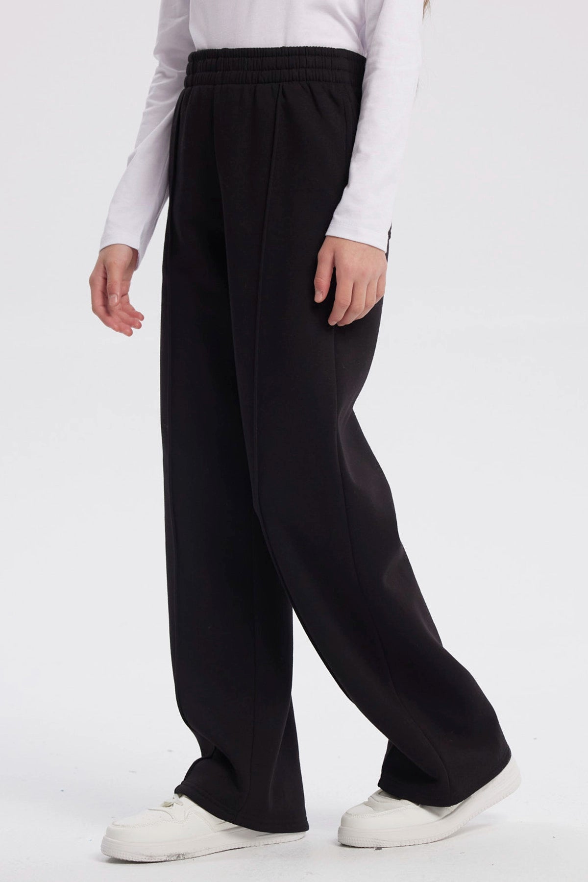 Pantalón buzo negro para niña con pierna ancha sin estampa visible diseño liso y cintura elástica para comodidad