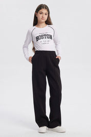 Pantalón buzo negro para niña con pierna ancha sin estampa visible diseño liso y cintura elástica para comodidad