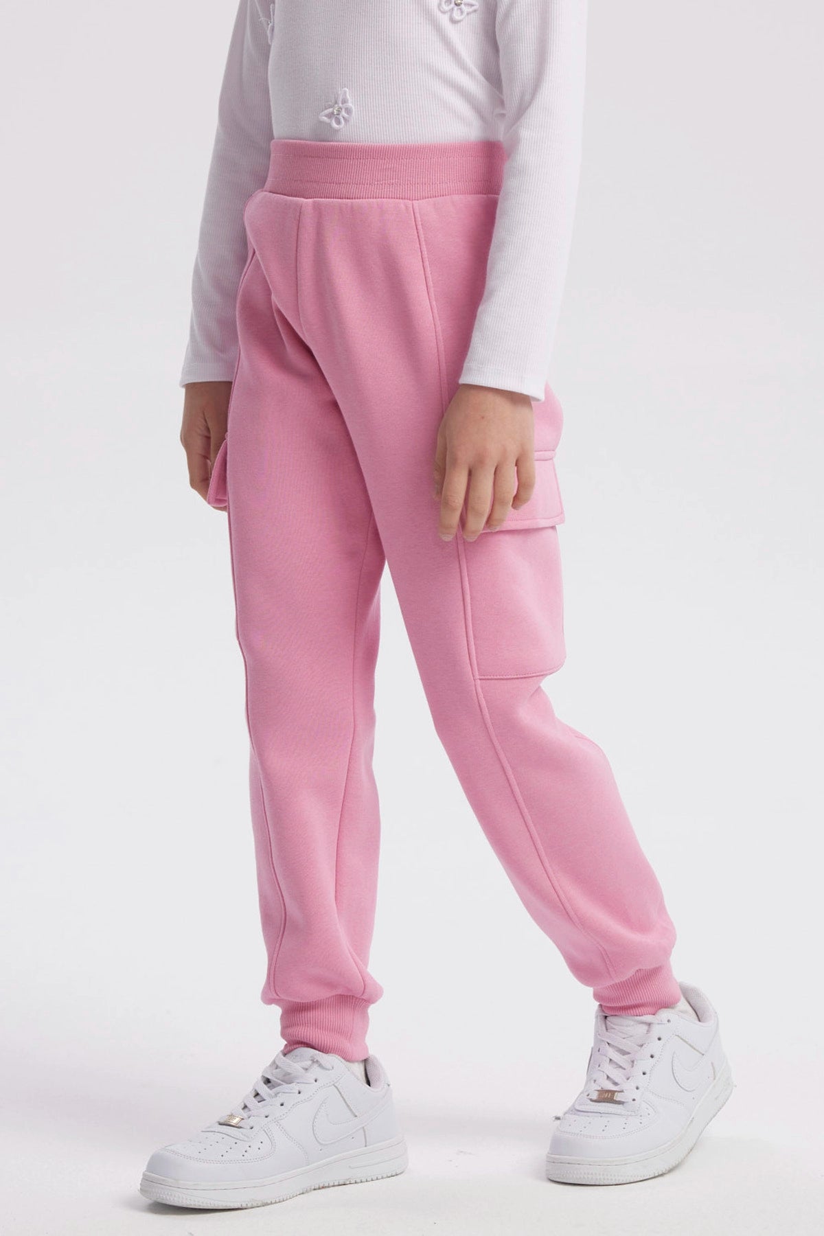 Pantalón buzo pitillo rosado para niña con cintura elástica prenda lisa sin estampa ideal para actividades cotidianas