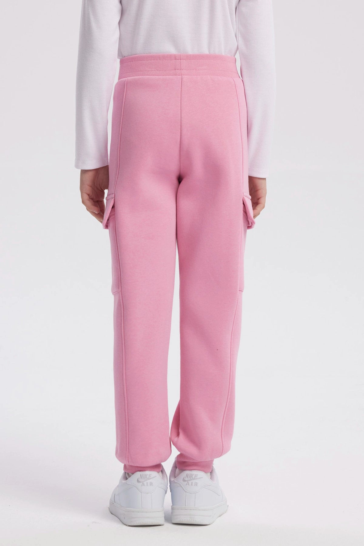 Pantalón buzo pitillo rosado para niña con cintura elástica prenda lisa sin estampa ideal para actividades cotidianas