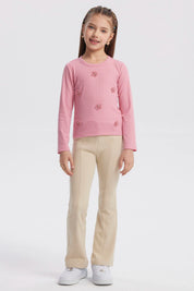 Polera slim rosada para niña con pequeñas flores bordadas en el frente diseño delicado y textura acanalada lisa