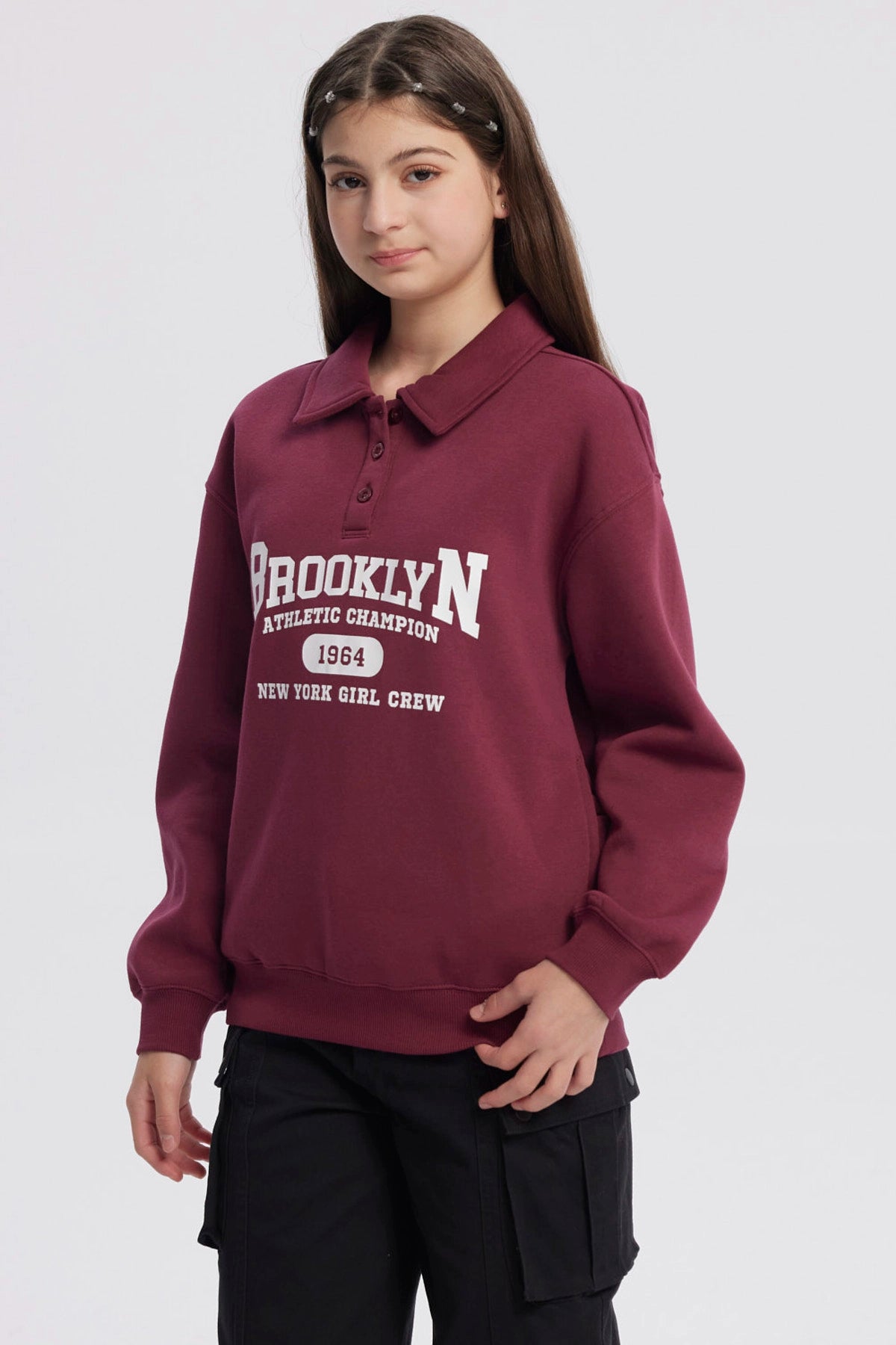 Polerón niña burdeo con cuello camisero y texto Brooklyn en el frente estilo deportivo casual