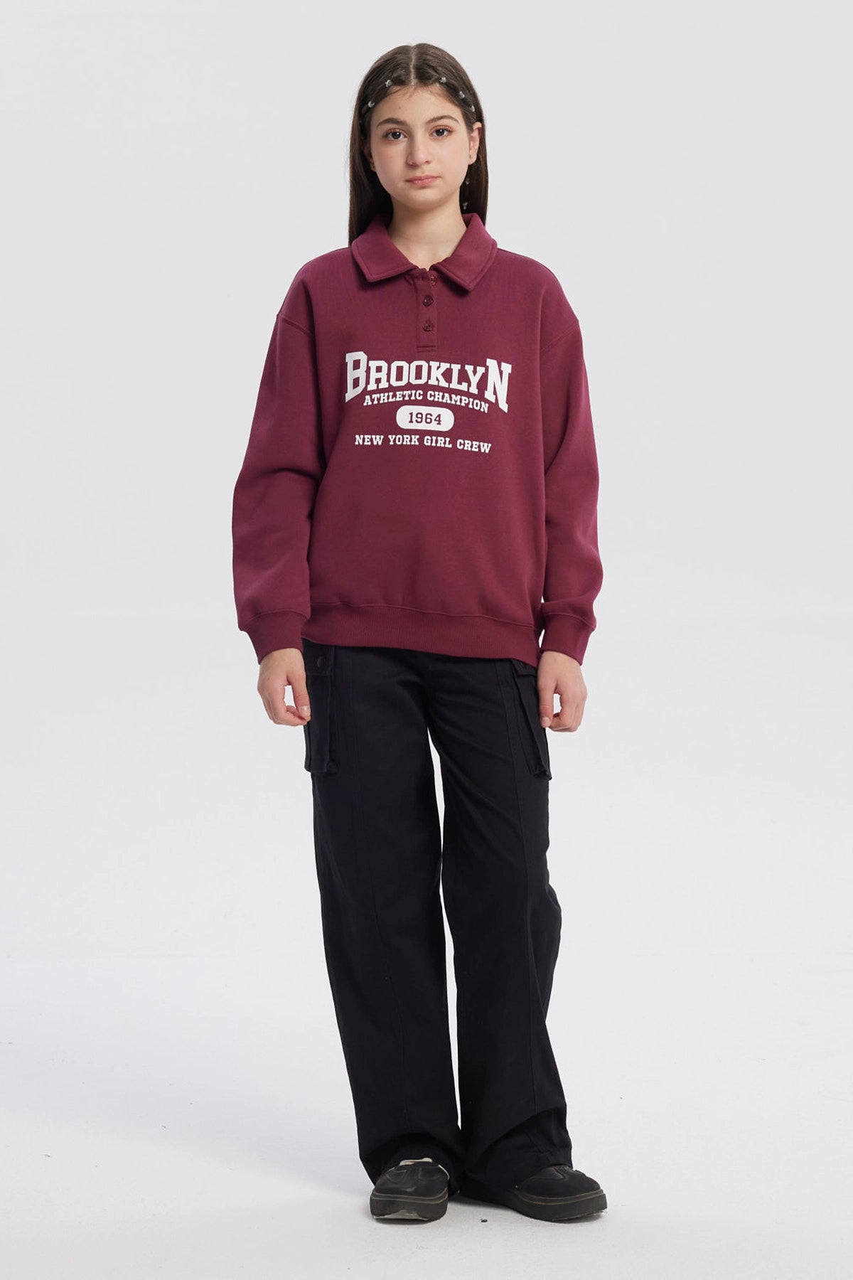 Polerón niña burdeo con cuello camisero y texto Brooklyn en el frente estilo deportivo casual