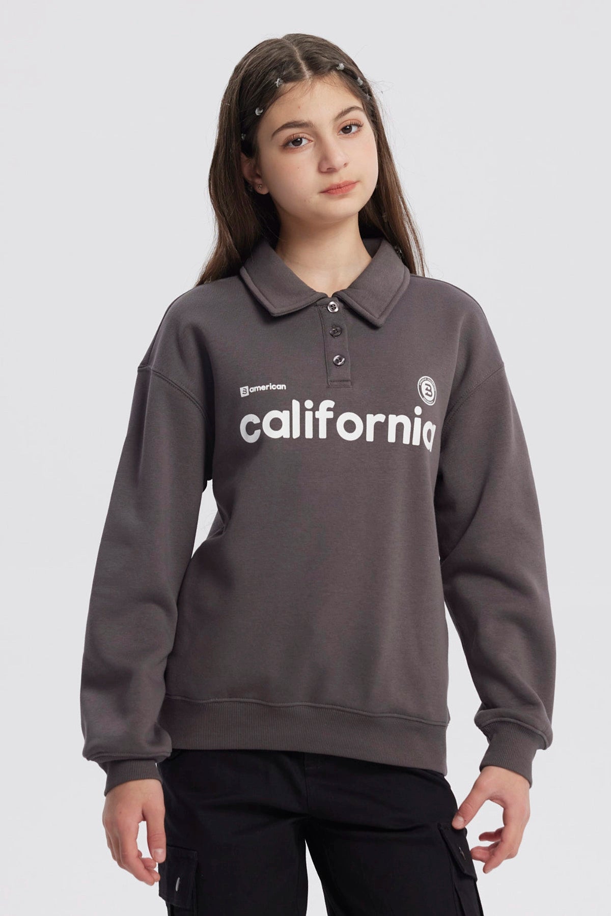 Polerón niña marengo con cuello camisero y texto California en el pecho diseño casual ideal para días frescos