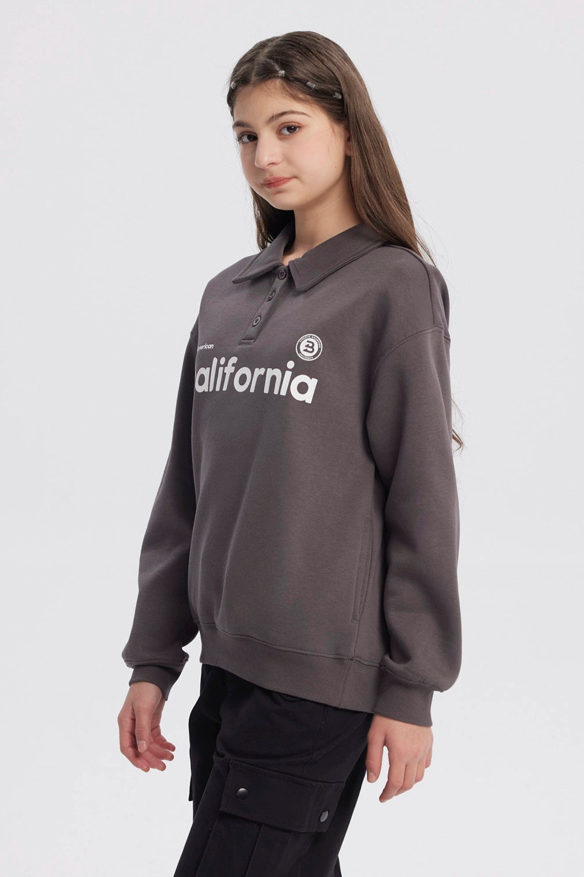 Polerón niña marengo con cuello camisero y texto California en el pecho diseño casual ideal para días frescos