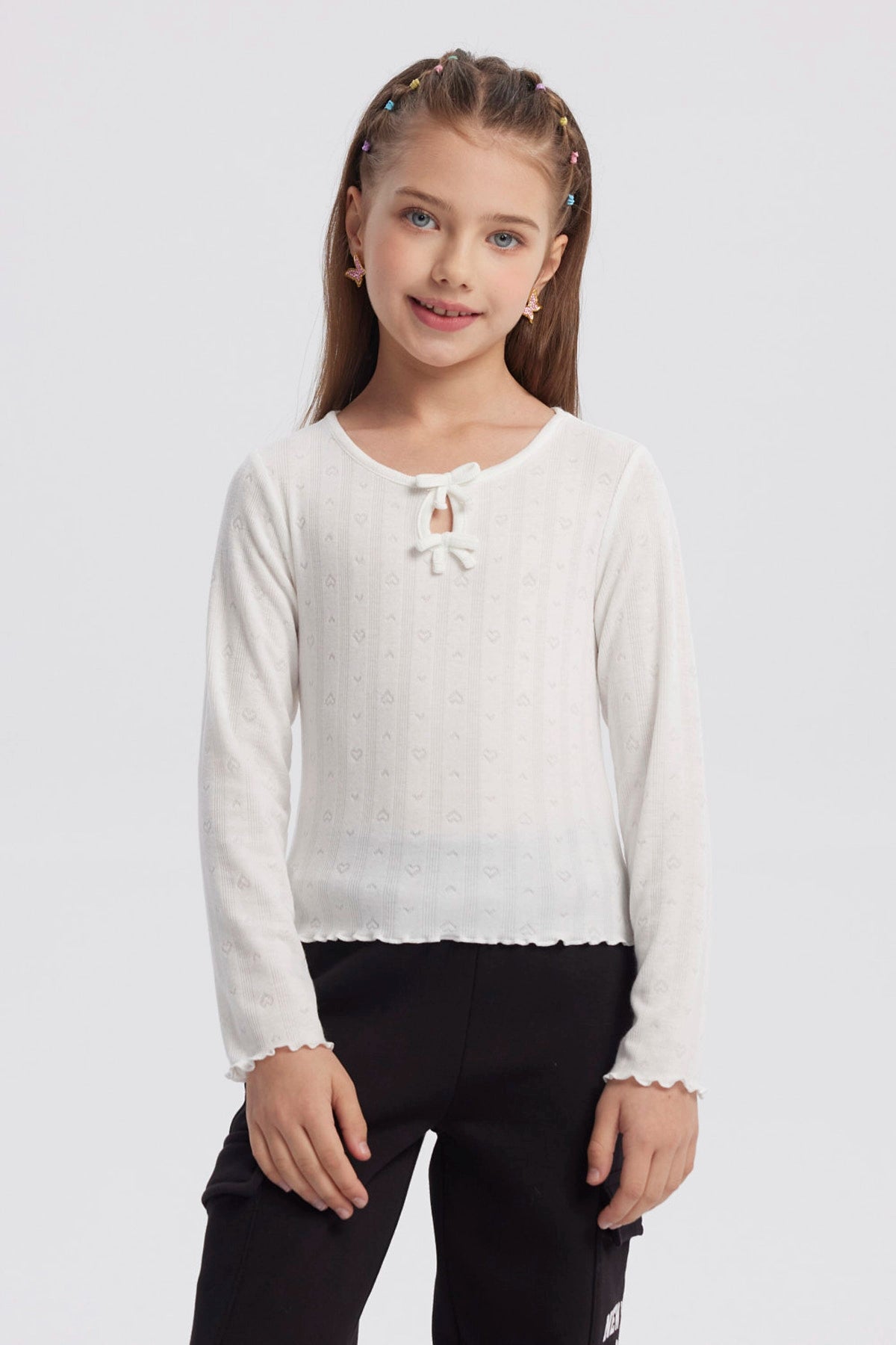 Polera crudo para niña con lazos en el cuello y detalles de corazones en patrón vertical prenda lisa y delicada
