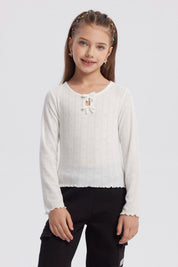 Polera crudo para niña con lazos en el cuello y detalles de corazones en patrón vertical prenda lisa y delicada