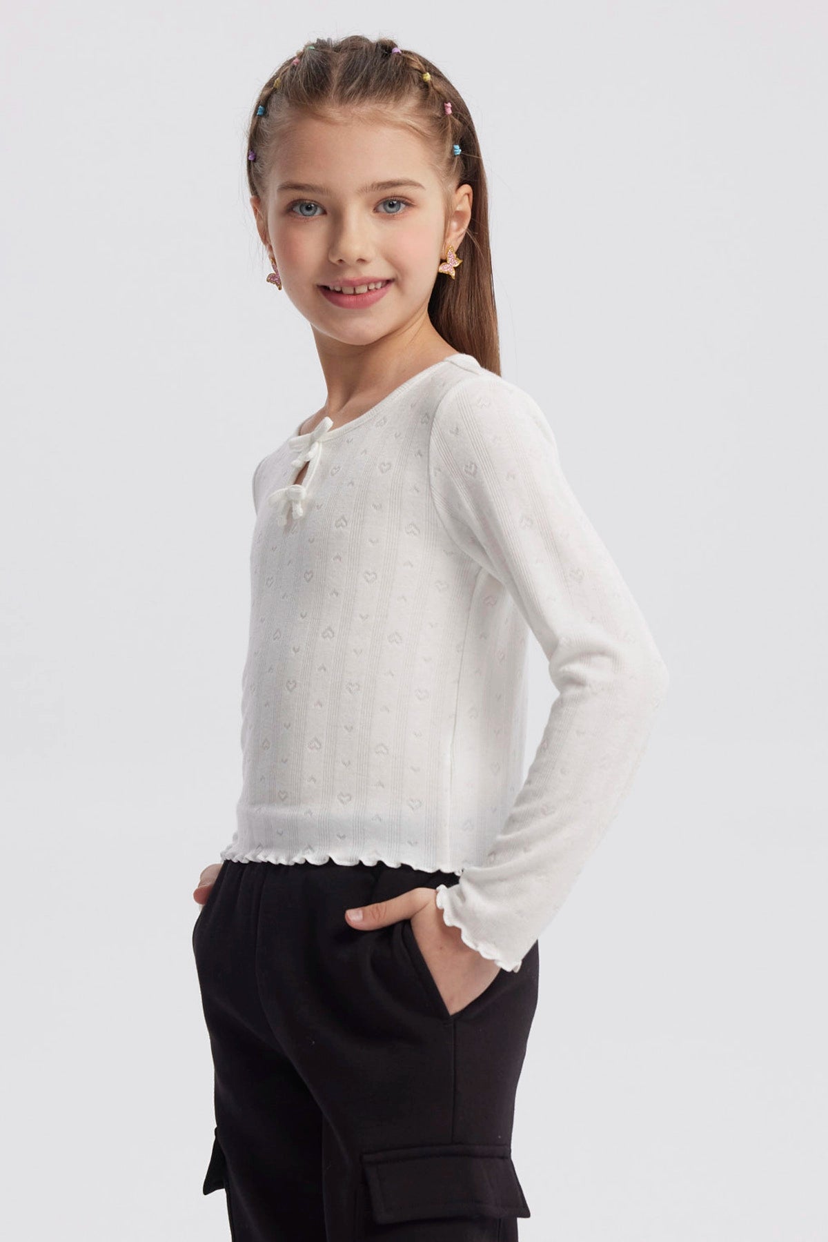 Polera crudo para niña con lazos en el cuello y detalles de corazones en patrón vertical prenda lisa y delicada