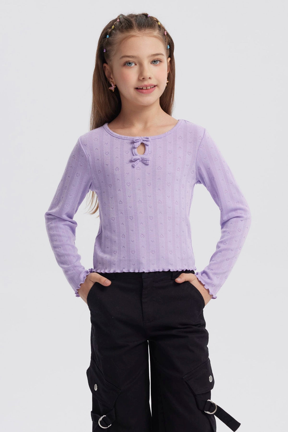 Polera lila para niña con lazos en el escote y diseño de corazones en relieve sin estampa lisa