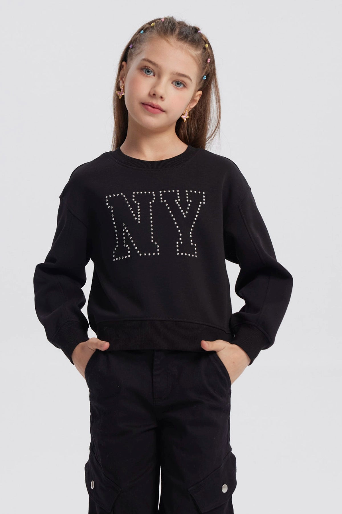 Polerón negro para niña con diseño de strass formando las letras NY en el pecho estilo casual y moderno
